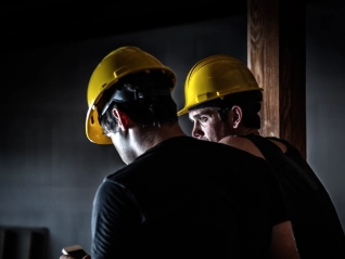 Two construction workers wearing yellow helmuts